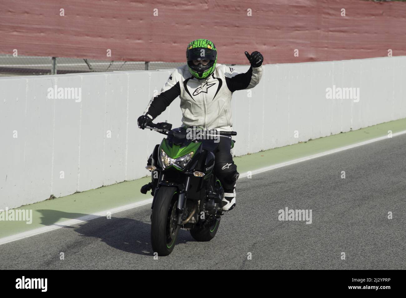 Un gros plan d'un motocycliste debout sur une piste prête pour la course Banque D'Images