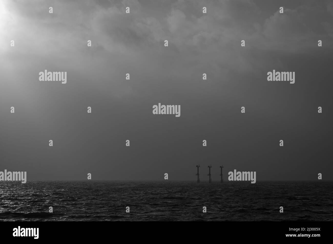Vue sur Solent depuis le front de mer de Southsea, Portsmouth, Hants, Angleterre avec les balises de navigation juste visibles à l'approche d'une douche. Banque D'Images