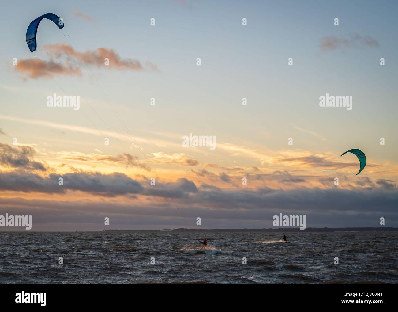 Kite surfeurs faisant le maximum d'une journée venteuse sur le Solent, juste de la plage à Stokes Bay, Gosport, Hampshire, Angleterre, Royaume-Uni. Banque D'Images