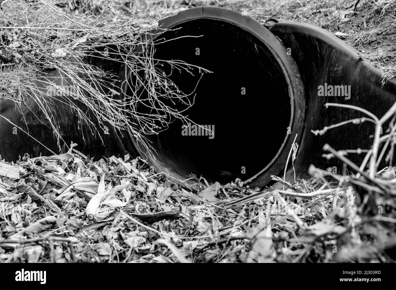 Ponceau de drainage en HDPE sous une entrée de route. Le tuyau est utilisé pour transporter les eaux pluviales entre les fossés. Banque D'Images