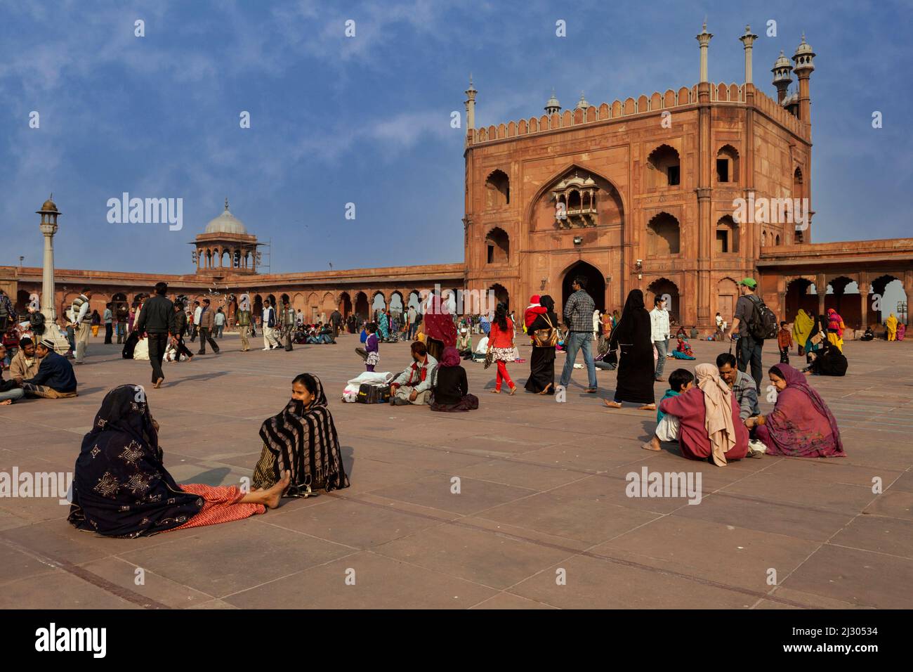 New Delhi, Inde. Cour de la Jama Masjid (mosquée du vendredi), la plus grande mosquée de l'Inde, construite de 1644 à 1656. En attente de prières en fin d'après-midi. Banque D'Images