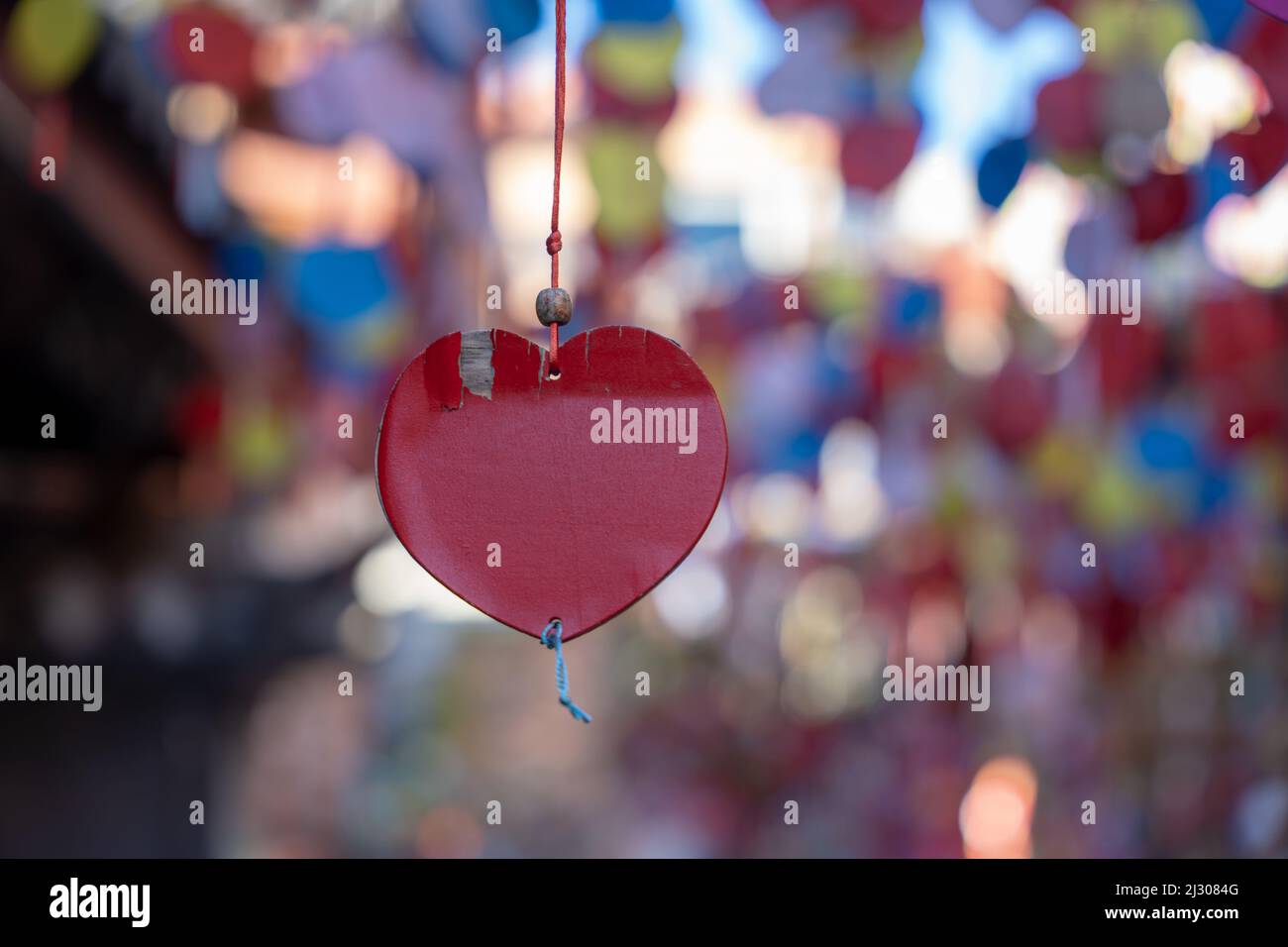 Cliché sélectif d'un coeur en verre rouge suspendu à un fil Banque D'Images