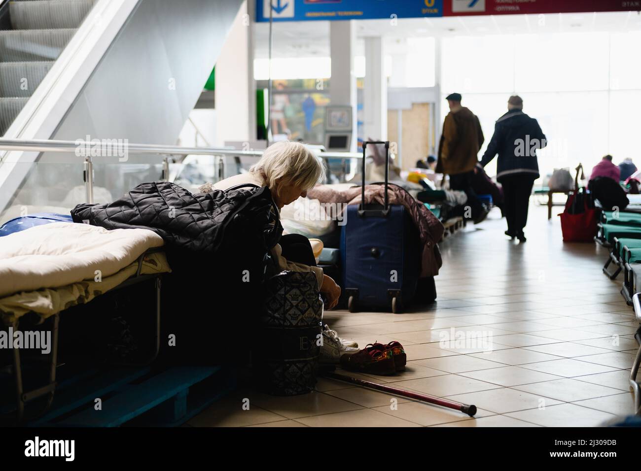 Dnipro, Ukraine - 04 avril 2022 : une femme âgée handicapée s'assoit sur un lit dans un centre commercial converti pour les réfugiés à Dnipro. Banque D'Images