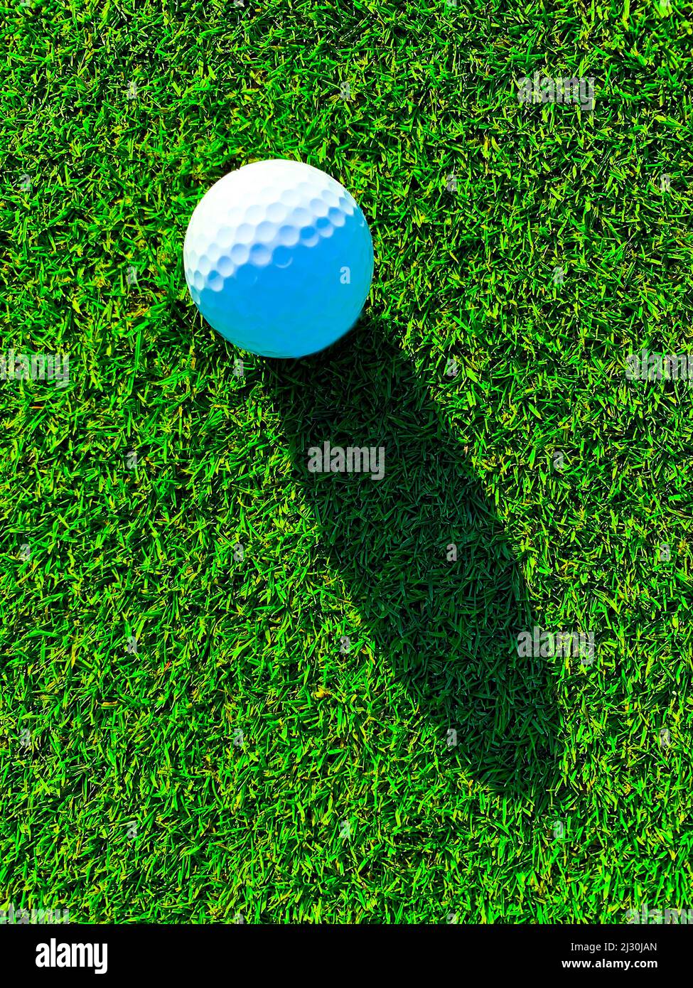 Balle de golf avec Shadow on the Grass sur le parcours de golf en Suisse Banque D'Images