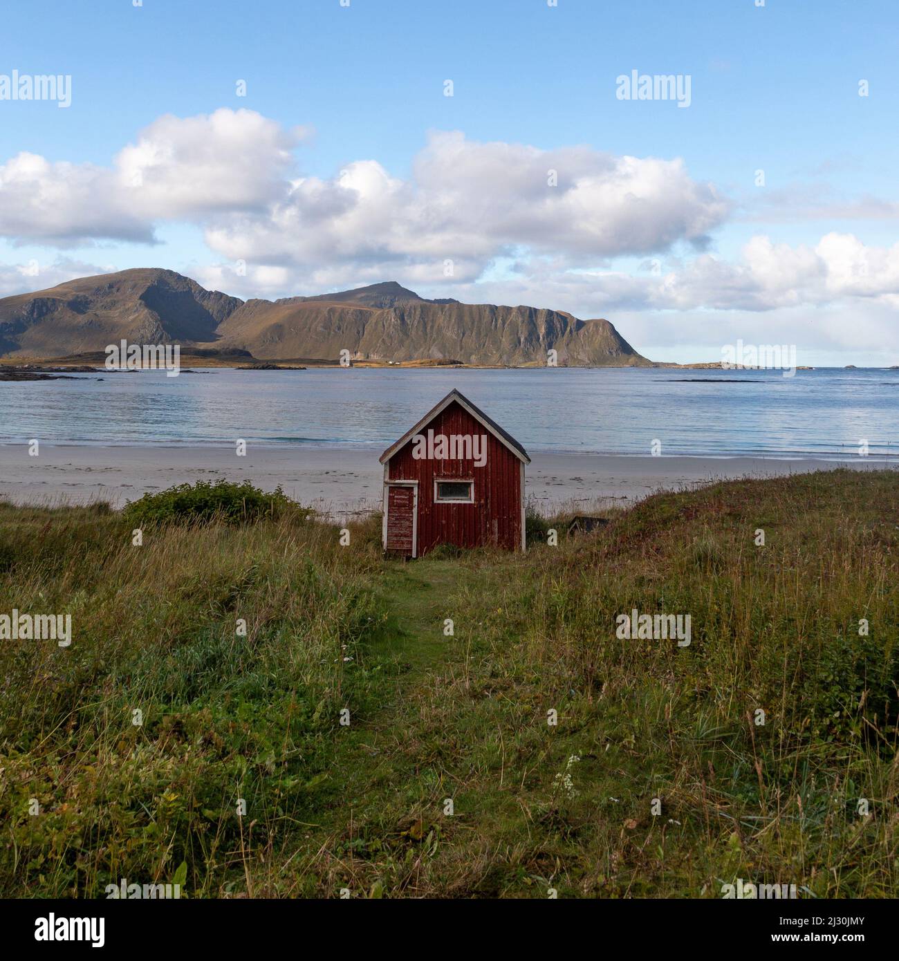 Petite maison rouge sur la plage à Rambergstranda, Flakstadoya, Lofoten, Norvège. Banque D'Images