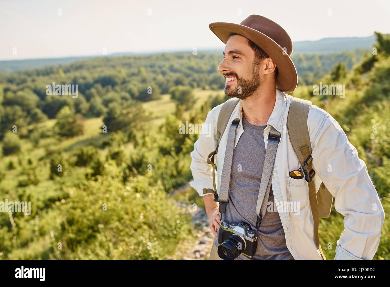 Jeune homme randonnée en vacances avec un sac à dos pendant la journée ensoleillée d'été en montagne Banque D'Images