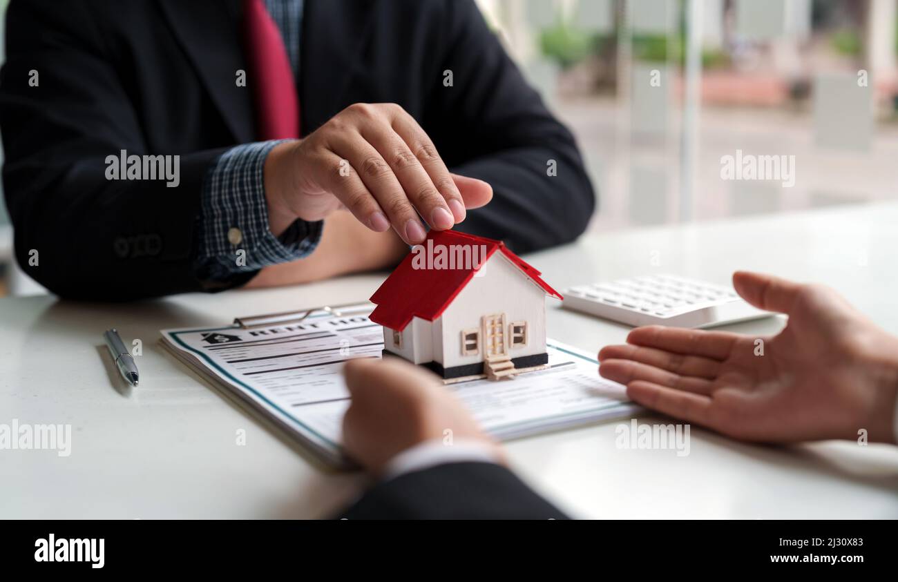 Agent immobilier directeur des ventes donnant le modèle de maison au client après la signature du contrat de location de contrat de vente d'achat, concernant l'hypothèque Banque D'Images