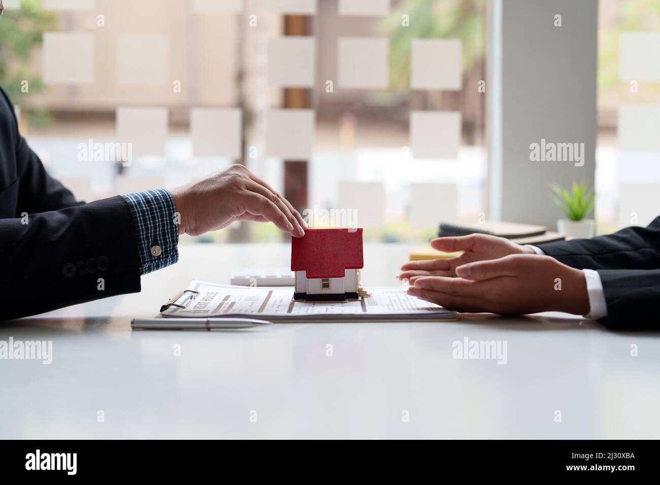 Agent immobilier directeur des ventes donnant le modèle de maison au client après la signature du contrat de location de contrat de vente d'achat, concernant l'hypothèque Banque D'Images