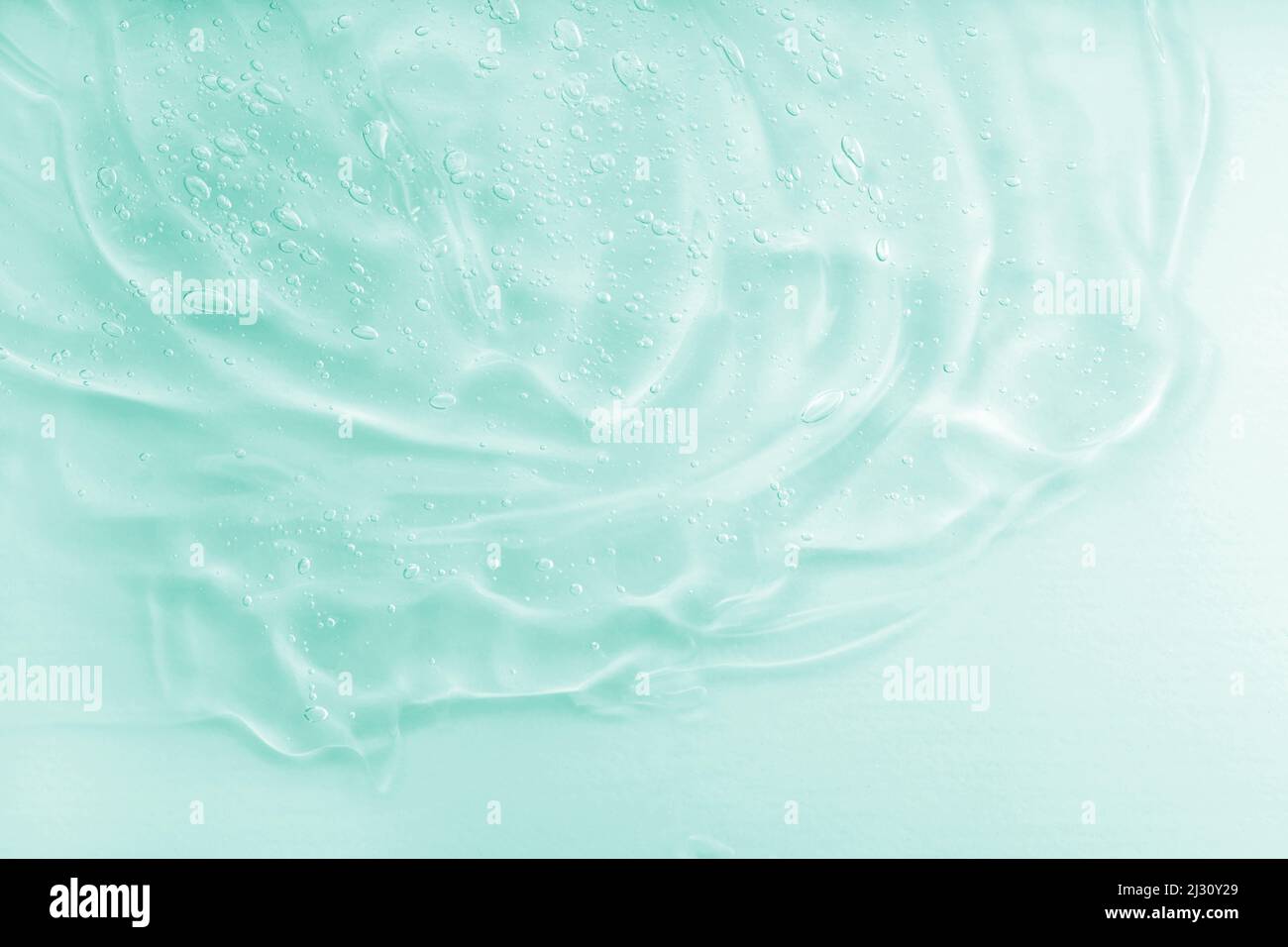 Taches d'huile verte liquide. Le concept de cosmétiques naturels. Échantillon de sérum transparent d'acide hyaluronique. Texture de gel cosmétique Aloe vera avec fond de bulles Banque D'Images