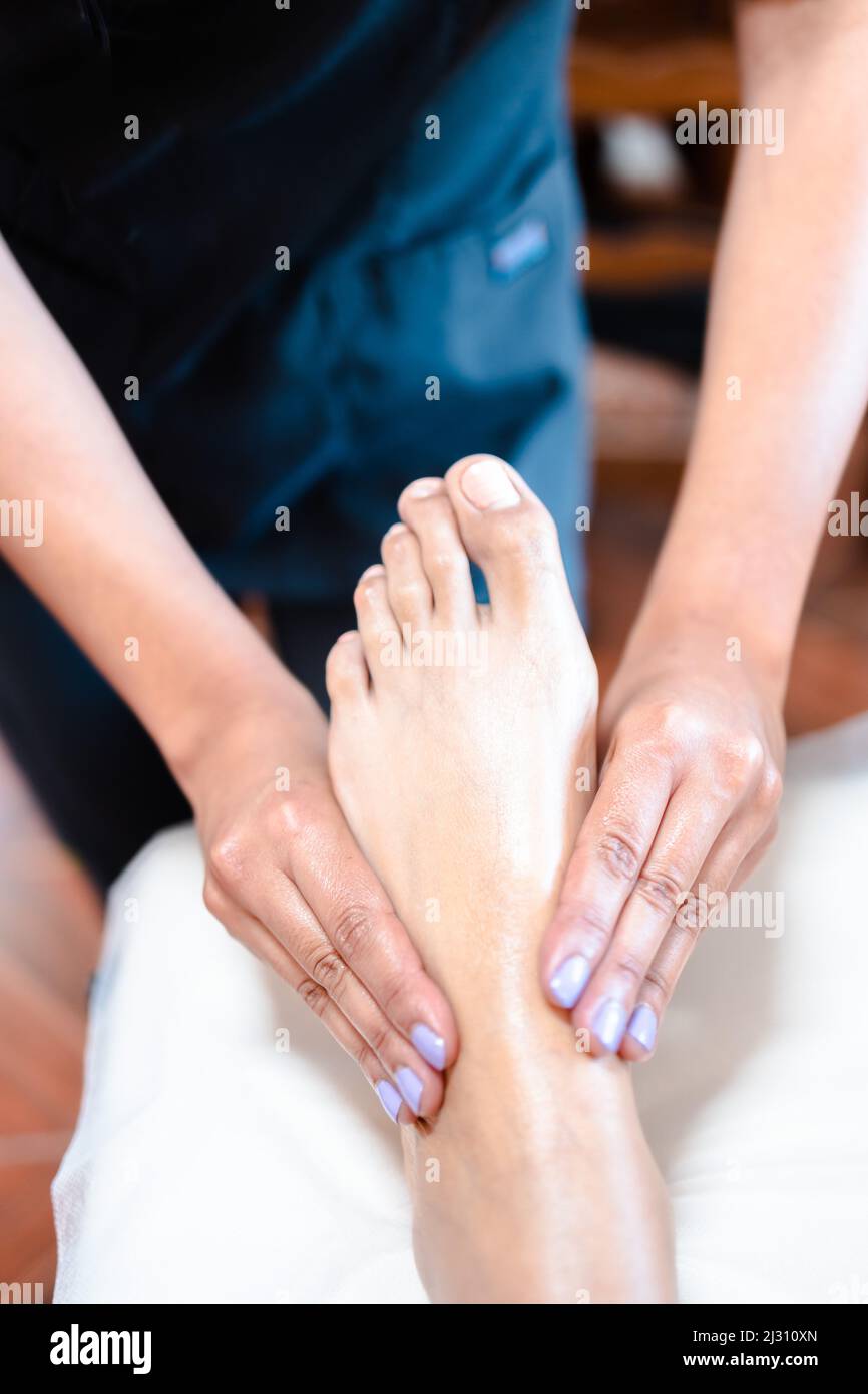 Un thérapeute méconnaissable fait un massage des pieds à une patiente. Centre de bien-être spa. Soins des pieds. Banque D'Images