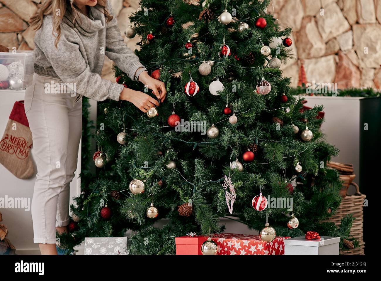 Cela devrait faire l'affaire. Photo courte d'une femme méconnue qui place des décorations sur un arbre de Noël à l'intérieur de la maison pendant la journée. Banque D'Images