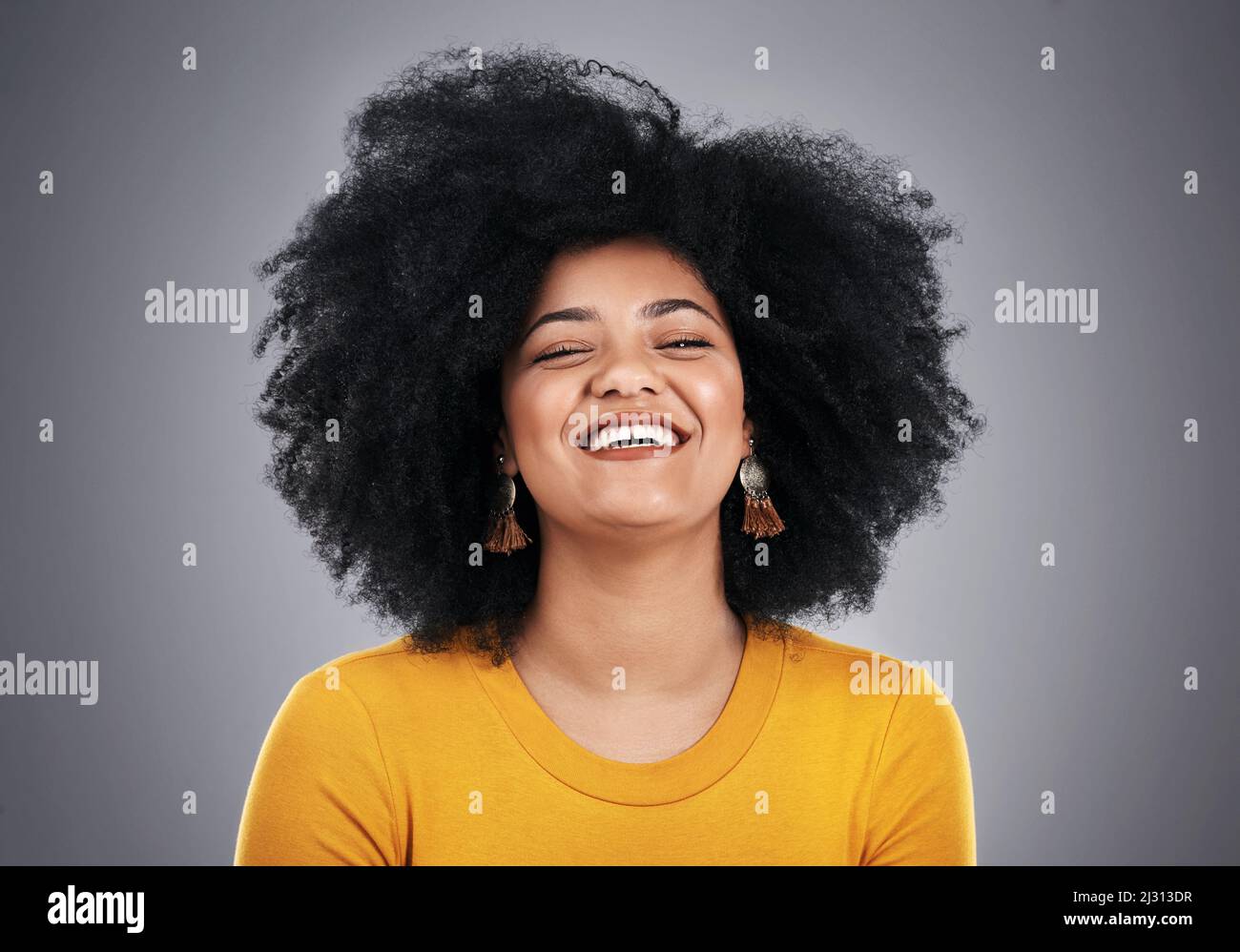 Brillent avec ce sourire glorieux. Photo en studio d'une jeune femme attrayante posant sur un fond gris. Banque D'Images