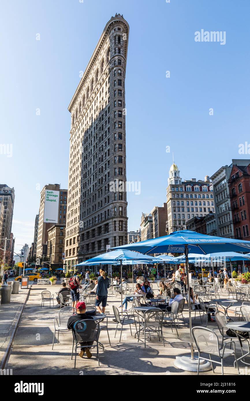 NEW YORK, USA - OCT 5, 2017: Les gens aiment s'asseoir à des chaises publiques de grand-voie avec WLAN gratuit et regarder la façade spectaculaire de Flatiron buildin Banque D'Images