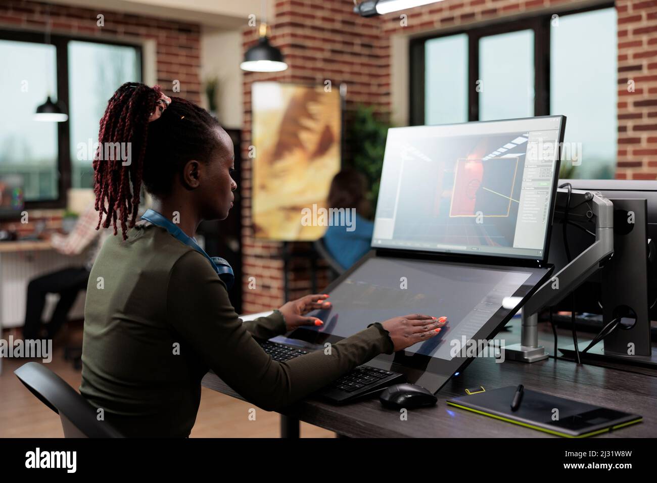 3D artistes numériques assis à un bureau d'ordinateur tout en travaillant sur le design environnemental. Responsable de l'équipe du département de production de l'agence de création développant une technologie de jeu professionnelle. Banque D'Images