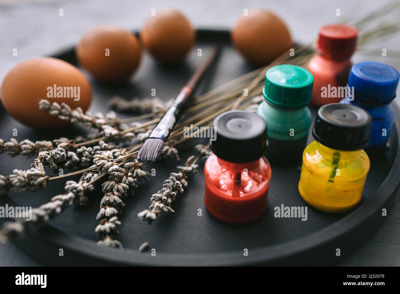 Peintures et brosses multicolores sur l'assiette avec œufs. Œufs de coloriage pour pâques concept de vacances. Banque D'Images