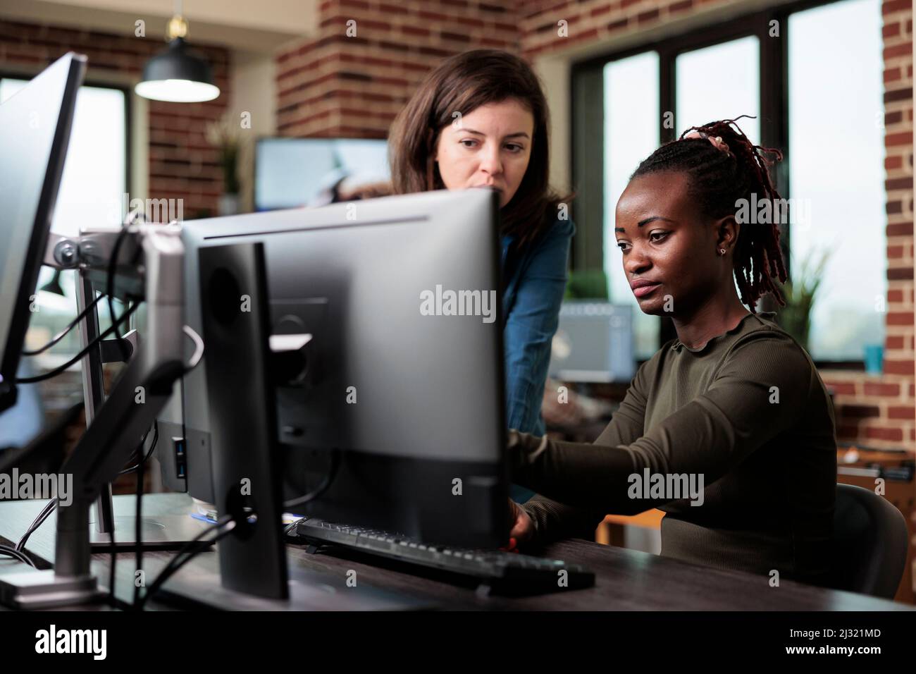 Les employés de bureau créatifs de l'entreprise assis à un bureau dans un espace de travail tout en discutant du développement graphique. Les développeurs professionnels de l'agence remue-méninges des idées de conception numérique à utiliser pour le projet. Banque D'Images