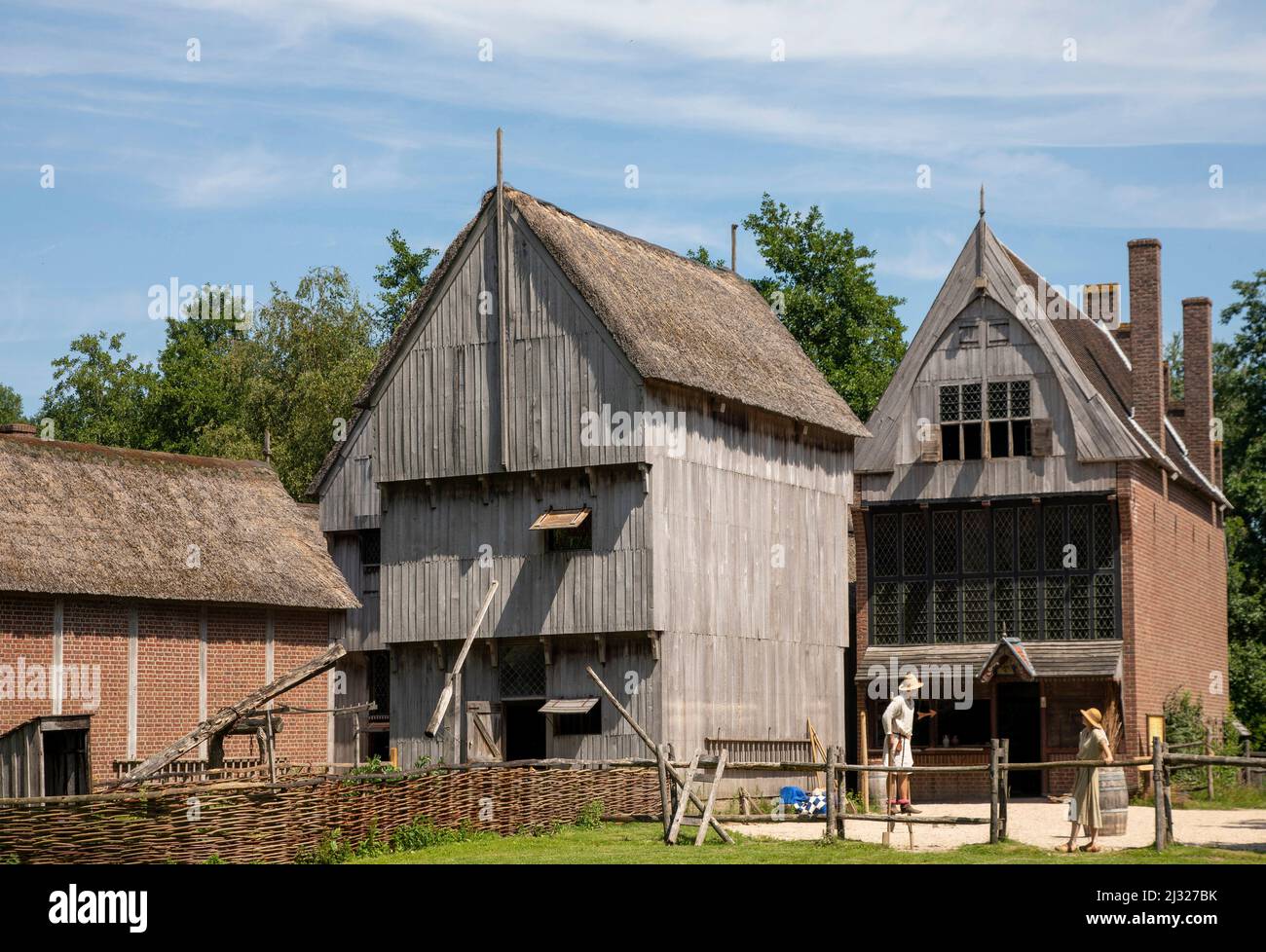 Pays-Bas, ville hollandaise au Moyen âge. Les femmes et l'homme parlent, tandis que l'homme marche sur des pilotis. Le parc Archeon montre ce petit méd Banque D'Images