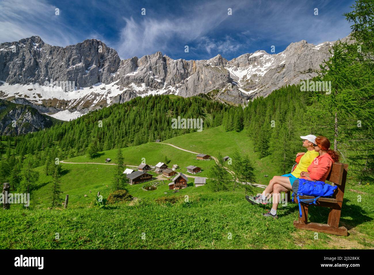 Homme et femme en randonnée s'assoient sur le banc et regardent Neustattalm et Dachstein, Neustattalm, Dachstein, Hallstatt, classé au patrimoine mondial de l'UNESCO, Styrie, Autriche Banque D'Images