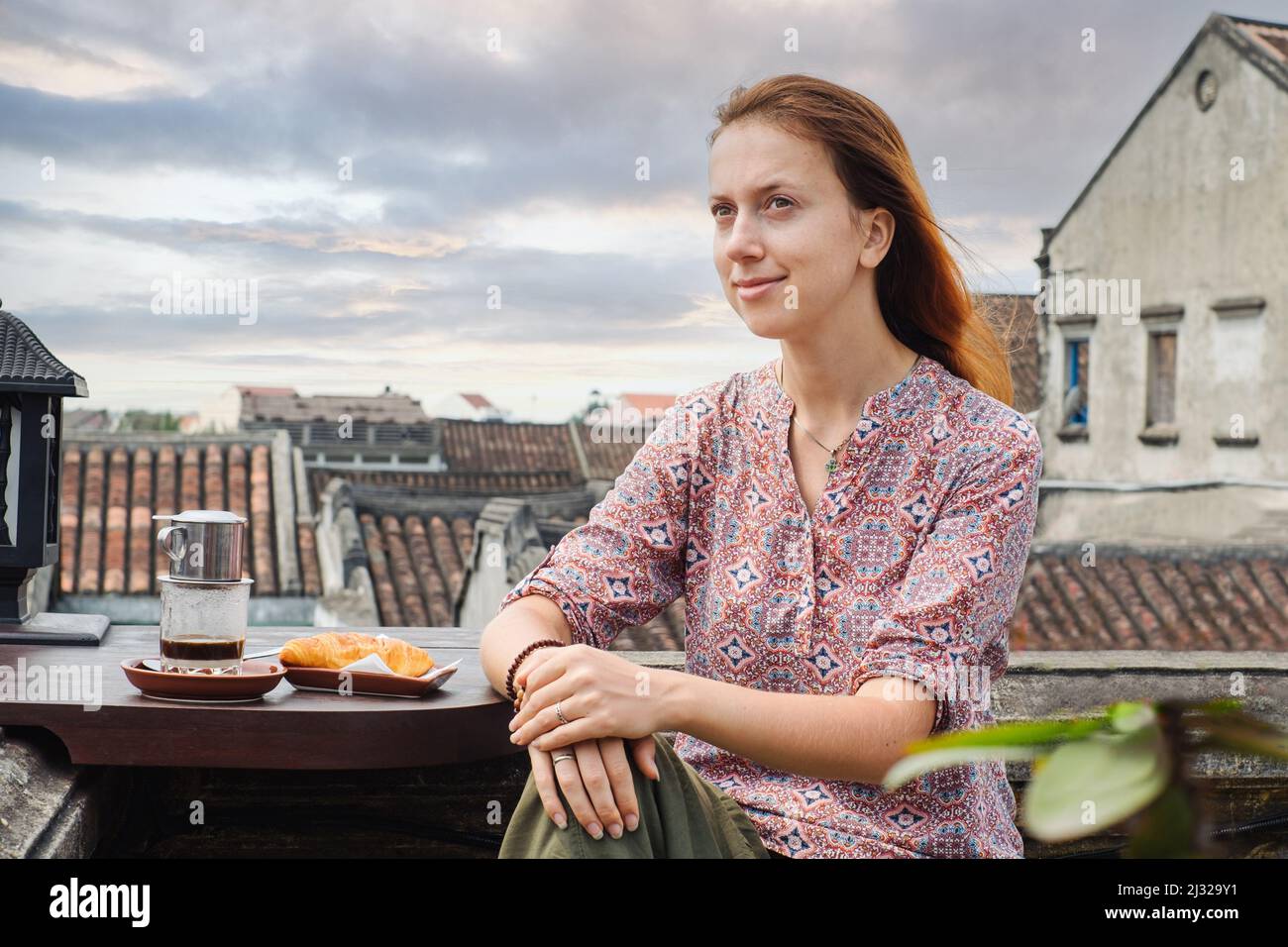 Une jeune femme boit du café vietnamien dans un café de la ville de Hoi an, au Vietnam Banque D'Images