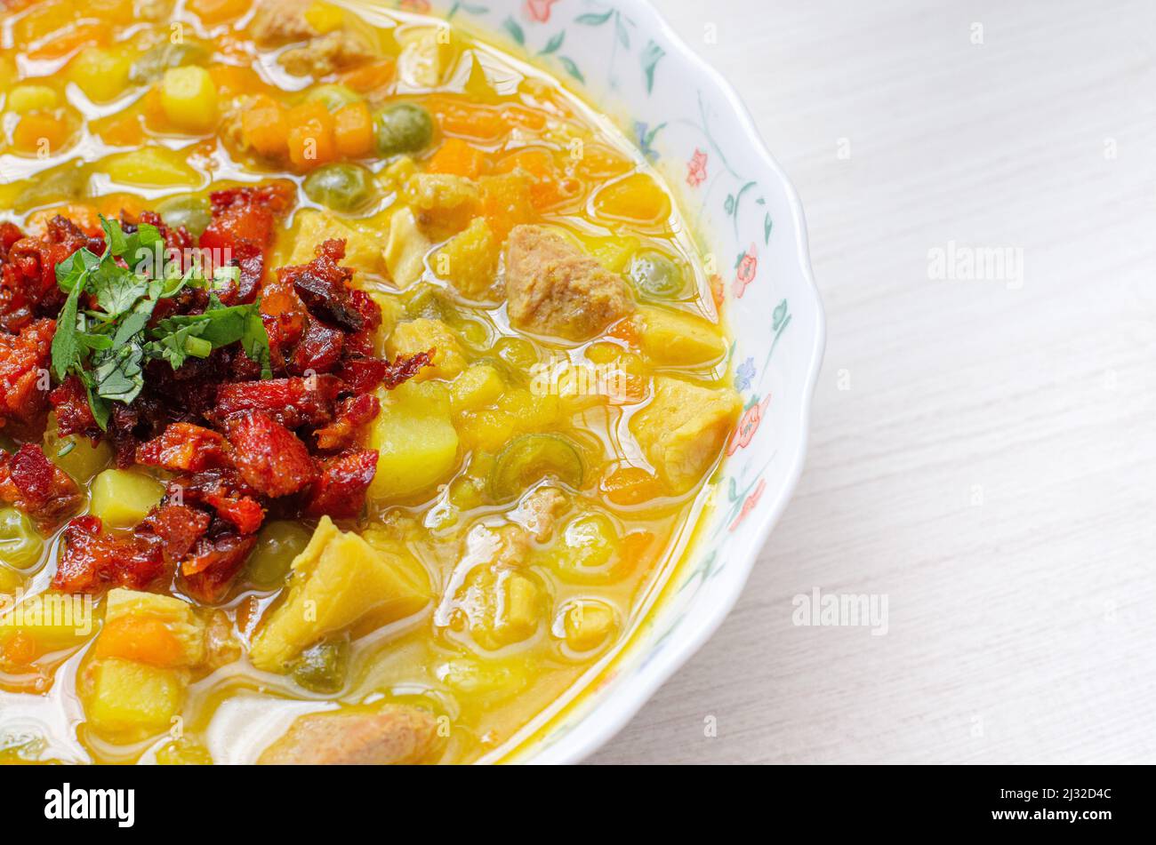 Assiette avec soupe de tripe, appelée mondongo, cuisine traditionnelle de Colombie, Amérique du Sud, sur bois clair. Banque D'Images