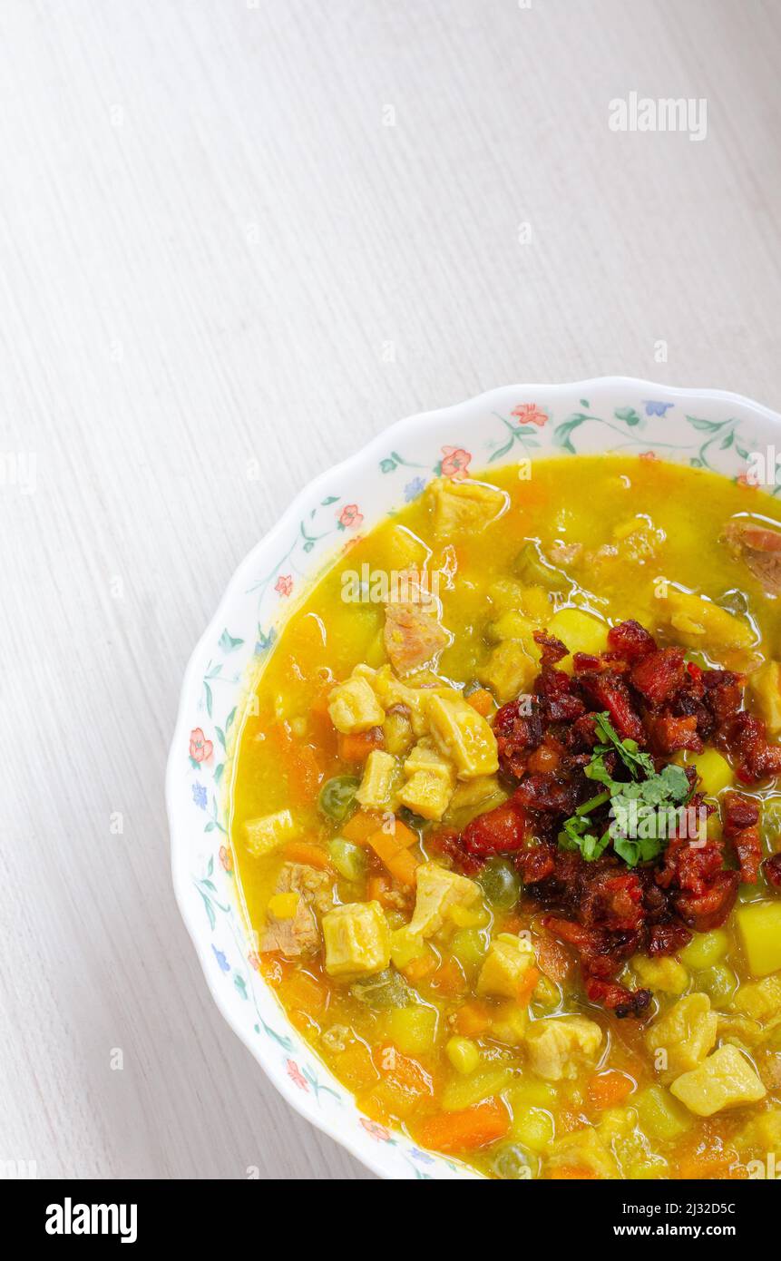 Assiette avec soupe de tripe, appelée mondongo, cuisine traditionnelle de Colombie, Amérique du Sud, sur bois clair. Banque D'Images