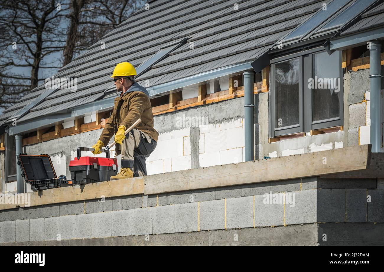 European House Construction and Professional Caucasian Worker dans sa 40s avec ses boîtes à outils. Développement de bâtiments résidentiels. Banque D'Images