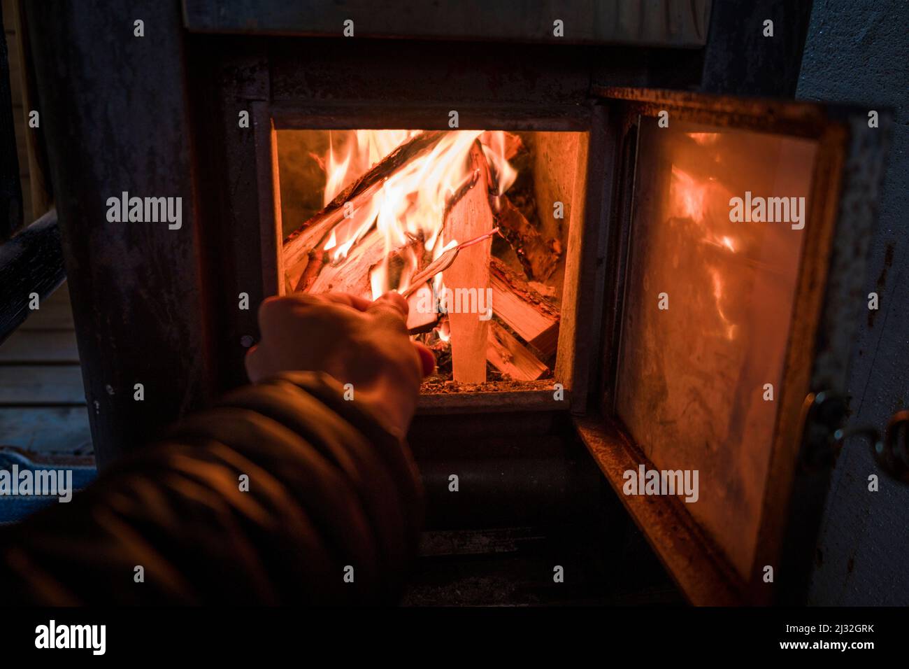 L'éclairage du chauffage du sauna avec du bois en Laponie, en Suède Banque D'Images