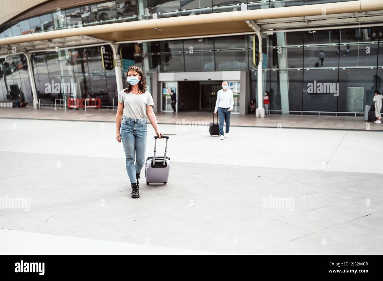 Une jeune femme quittant l'aéroport avec ses bagages prêts à découvrir une nouvelle destination Banque D'Images