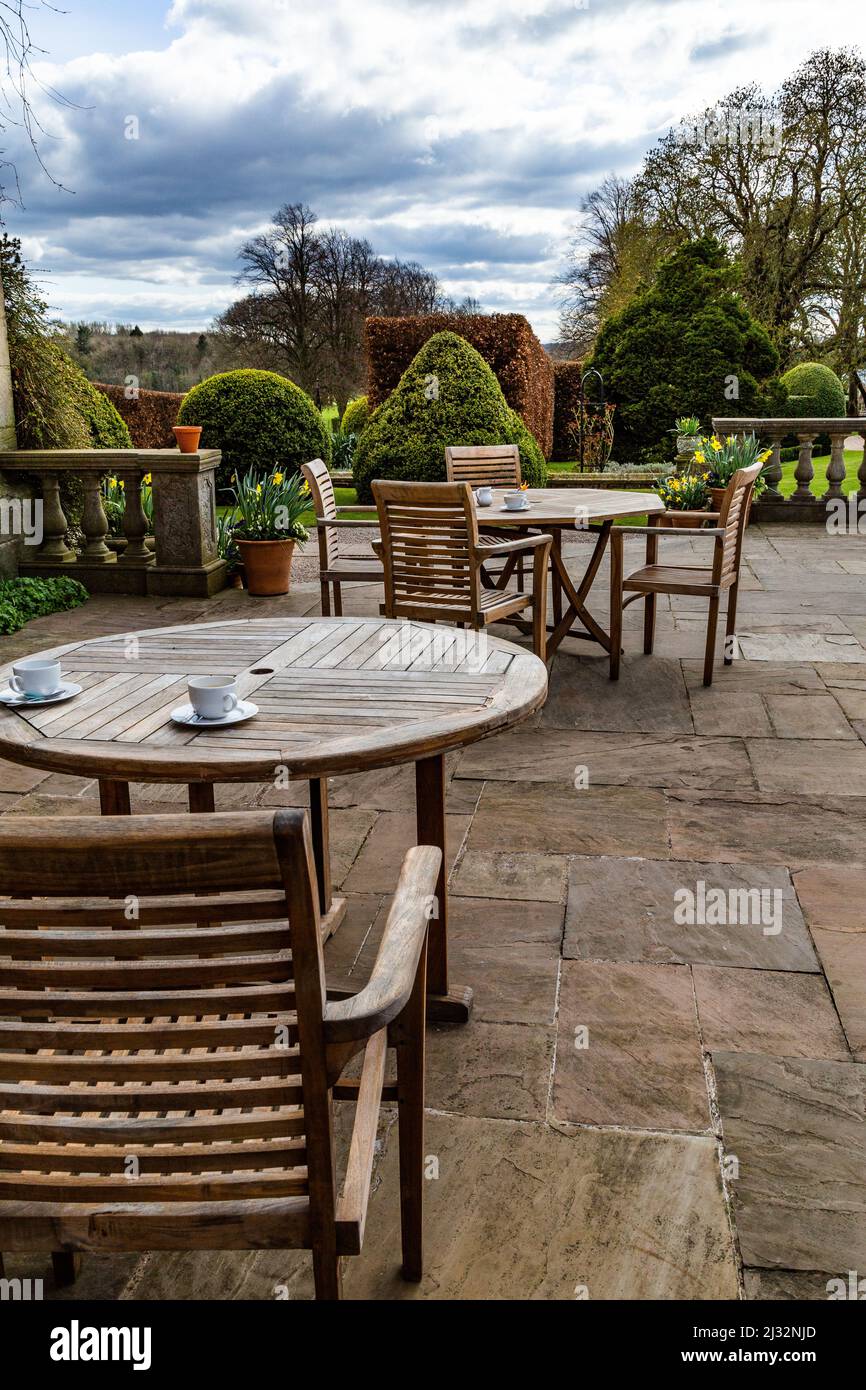 Tables et chaises de jardin en bois sur le patio de Goldsborough Hall, Knaresborough, North Yorkshire. Banque D'Images