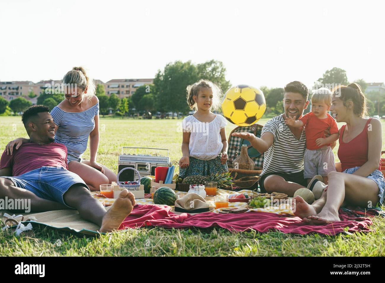 Familles heureuses s'amusant pique-niquer dans le parc en plein air en vacances d'été - Focus sur le visage d'homme africain Banque D'Images