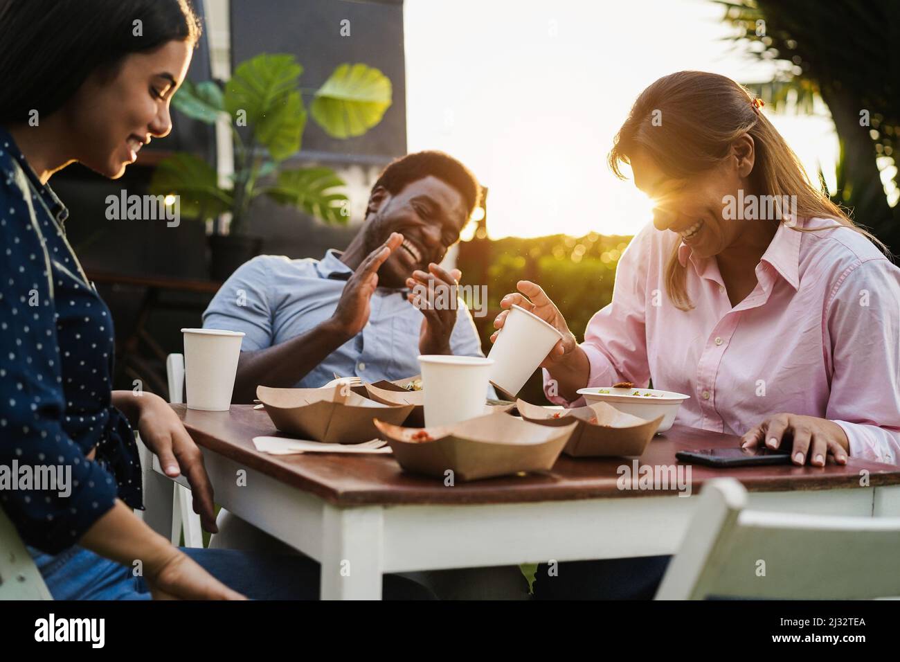 Les gens multiraciaux s'amusent à manger au restaurant de camion de nourriture en plein air - Focus sur la femme senior tenant la main de verre Banque D'Images