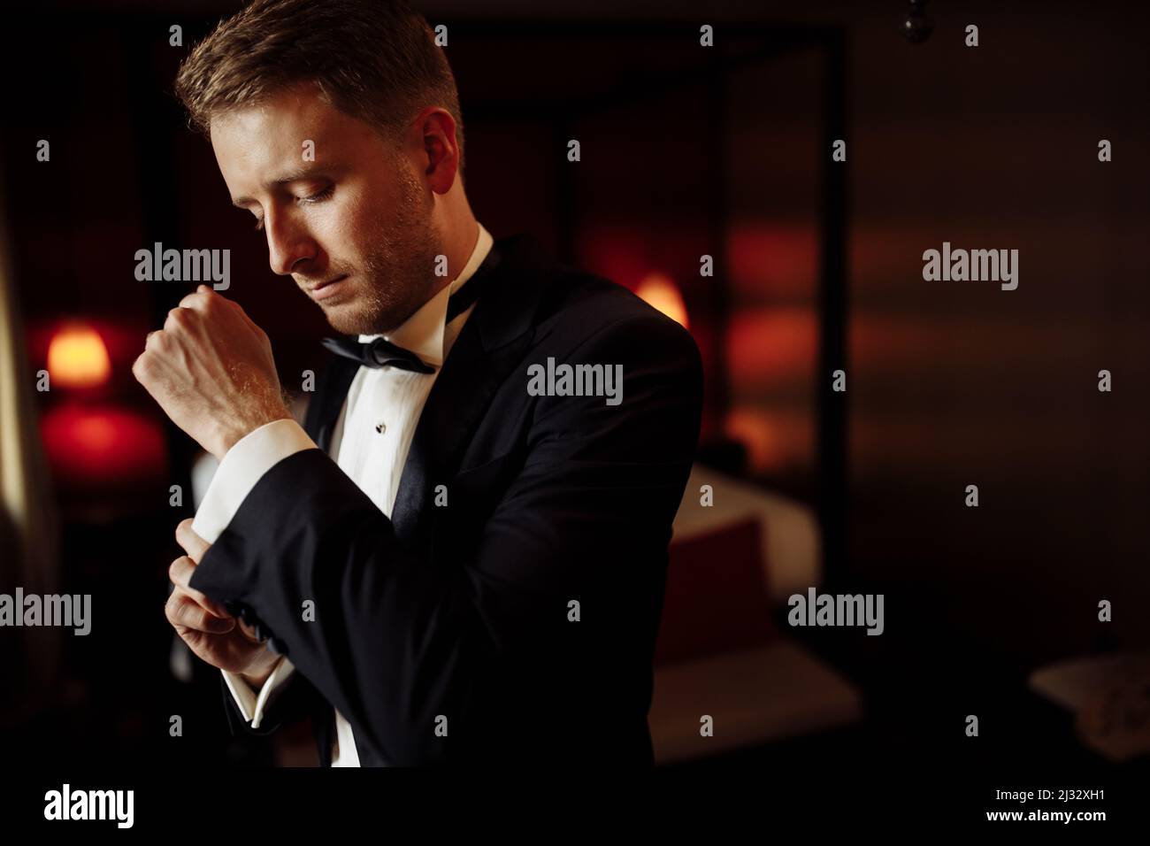 Un gros plan d'un châssis court d'un marié dans un costume classique coûteux et une chemise blanche se prépare à l'événement. Le futur mari est pressé Banque D'Images