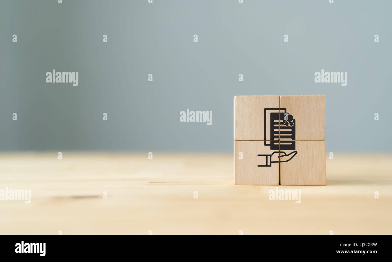 Concept de certification et de normalisation ISO. Certification, gestion de la qualité, assurance pour l'industrie. Blocs cubes en bois avec support à la main Banque D'Images