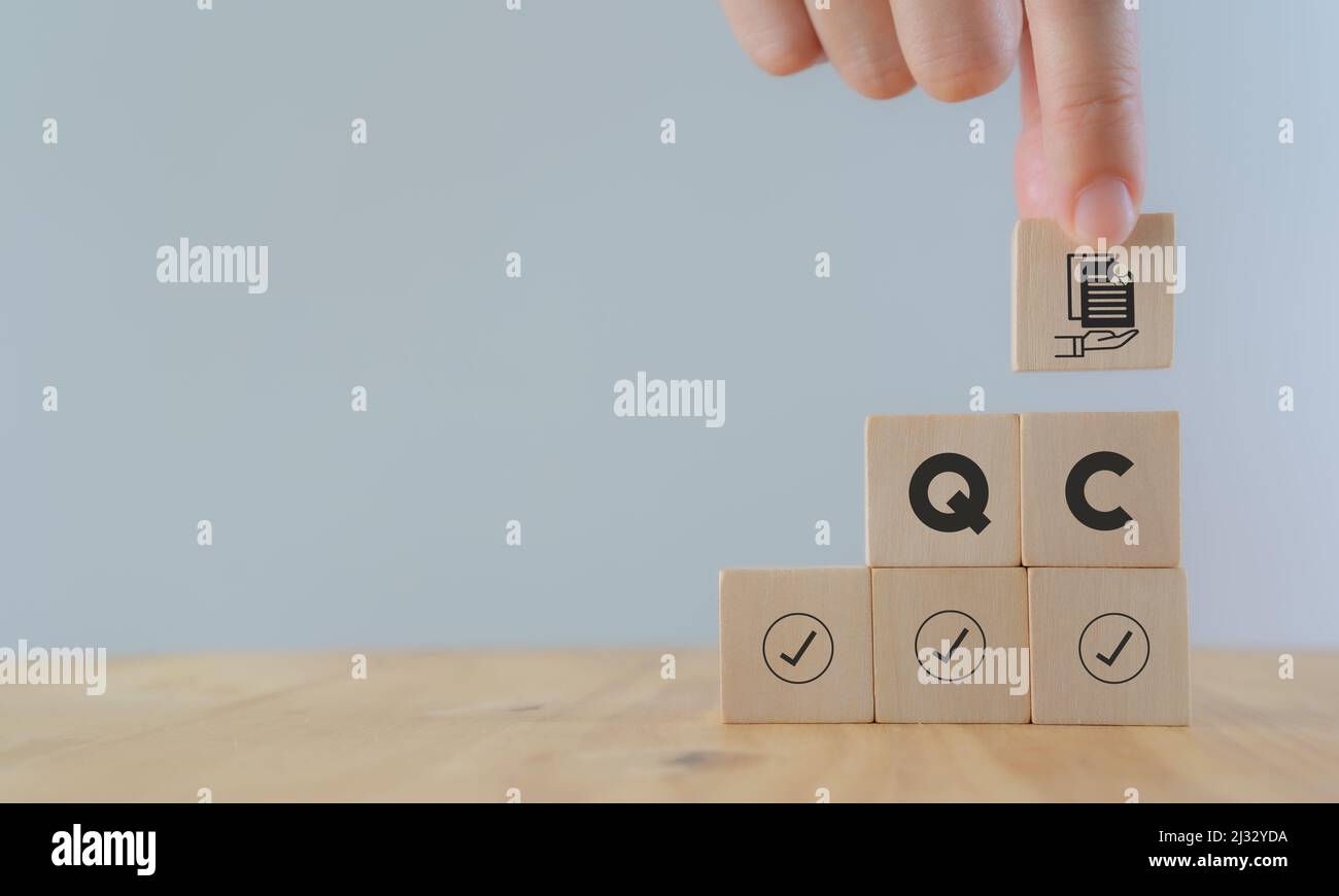 Concept de contrôle qualité (CQ). Pour les entreprises et l'industrie. Qualité standard, garantie, processus, contrôle et approbation. Tenir les cubes en bois à la main avec de la guaran Banque D'Images