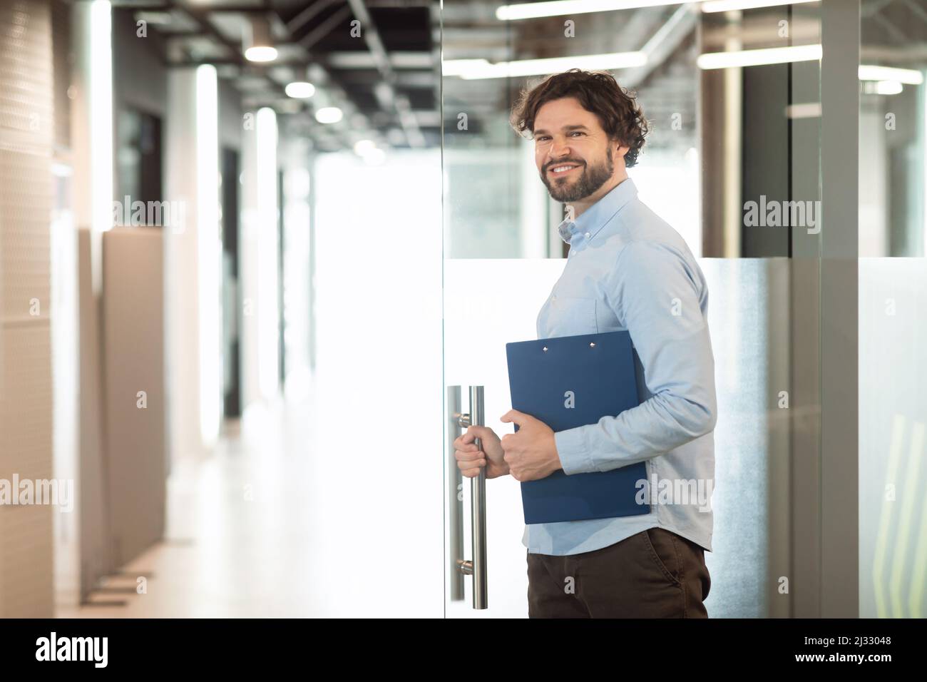 Portrait d'un homme d'affaires souriant posant en regardant l'appareil photo Banque D'Images