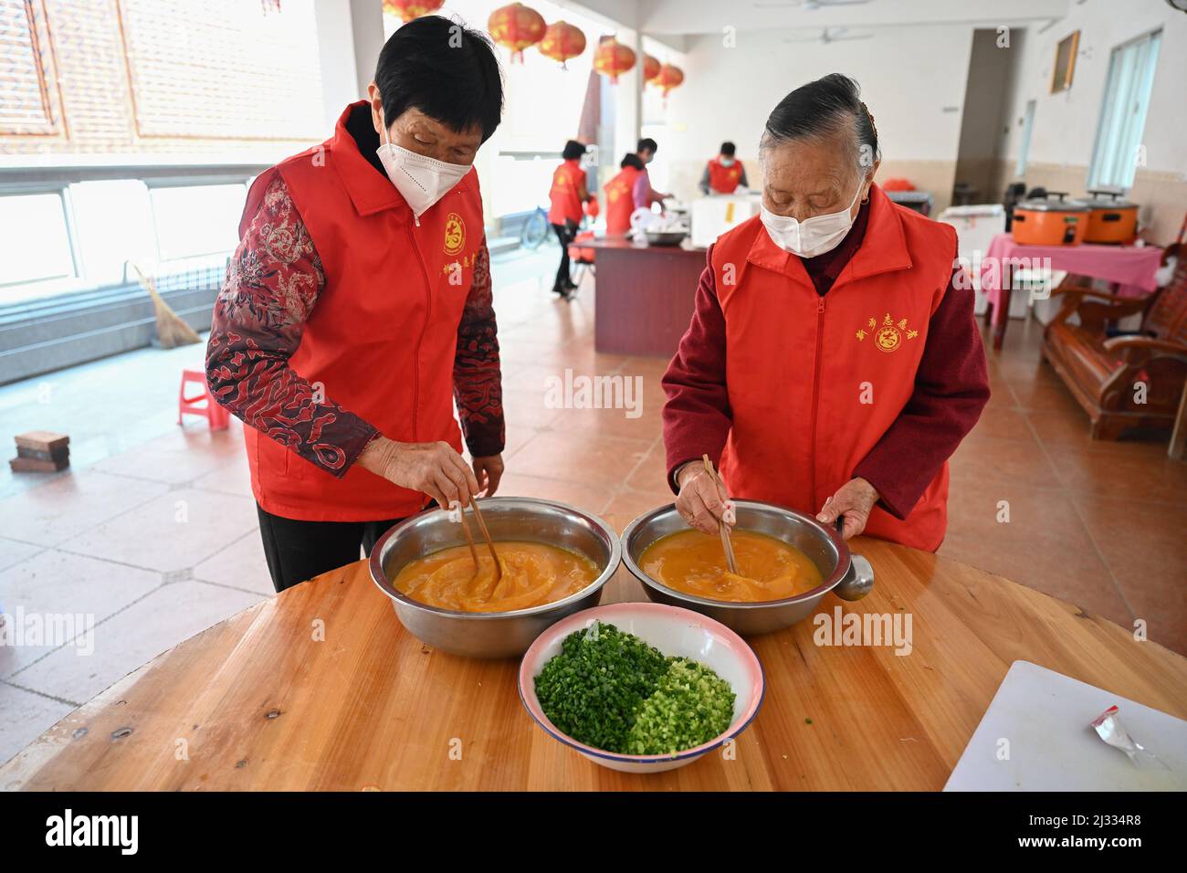 (220405) -- QUANZHOU, 5 avril 2022 (Xinhua) -- cuisiniers bénévoles cuisinent dans la communauté de Xinbu à Quanzhou, dans la province de Fujian, dans le sud-est de la Chine, 5 avril 2022. Un groupe de pannies locales, avec un âge moyen de plus de 70 ans, se sont volontaires pour cuisiner et livrer des repas aux travailleurs essentiels de première ligne à Quanzhou dans le cadre de la dernière résurgence de COVID-19. Ils ont préparé plus de 1 000 repas emballés jusqu'à présent. (Photo de Zhou Yi/Xinhua) Banque D'Images