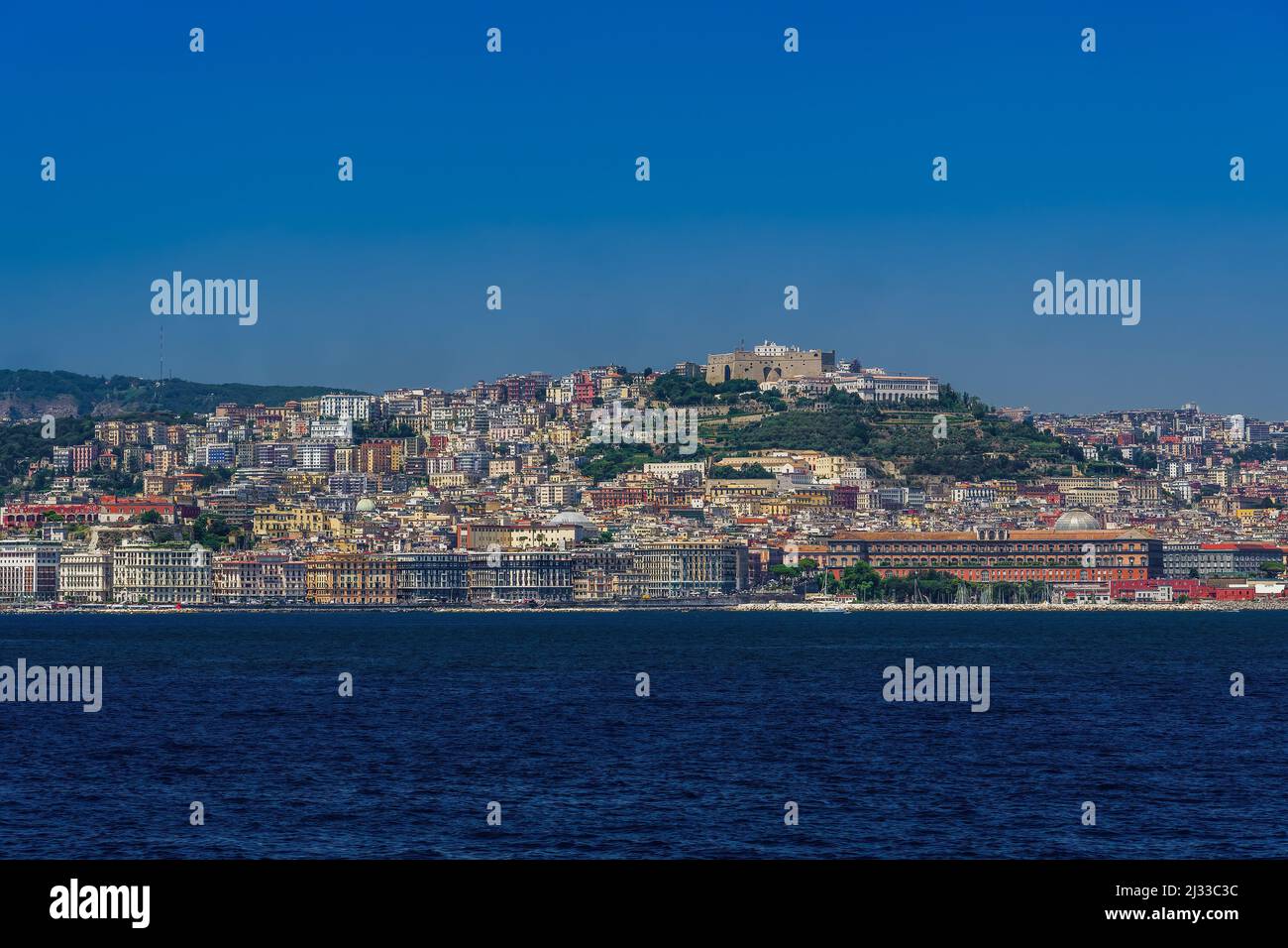 Naples Italie vue sur la mer côtière sous un ciel bleu sans nuages avec la forteresse médiévale Castel Sant'Elmo et les bâtiments en bord de mer visibles depuis un voilier. Banque D'Images