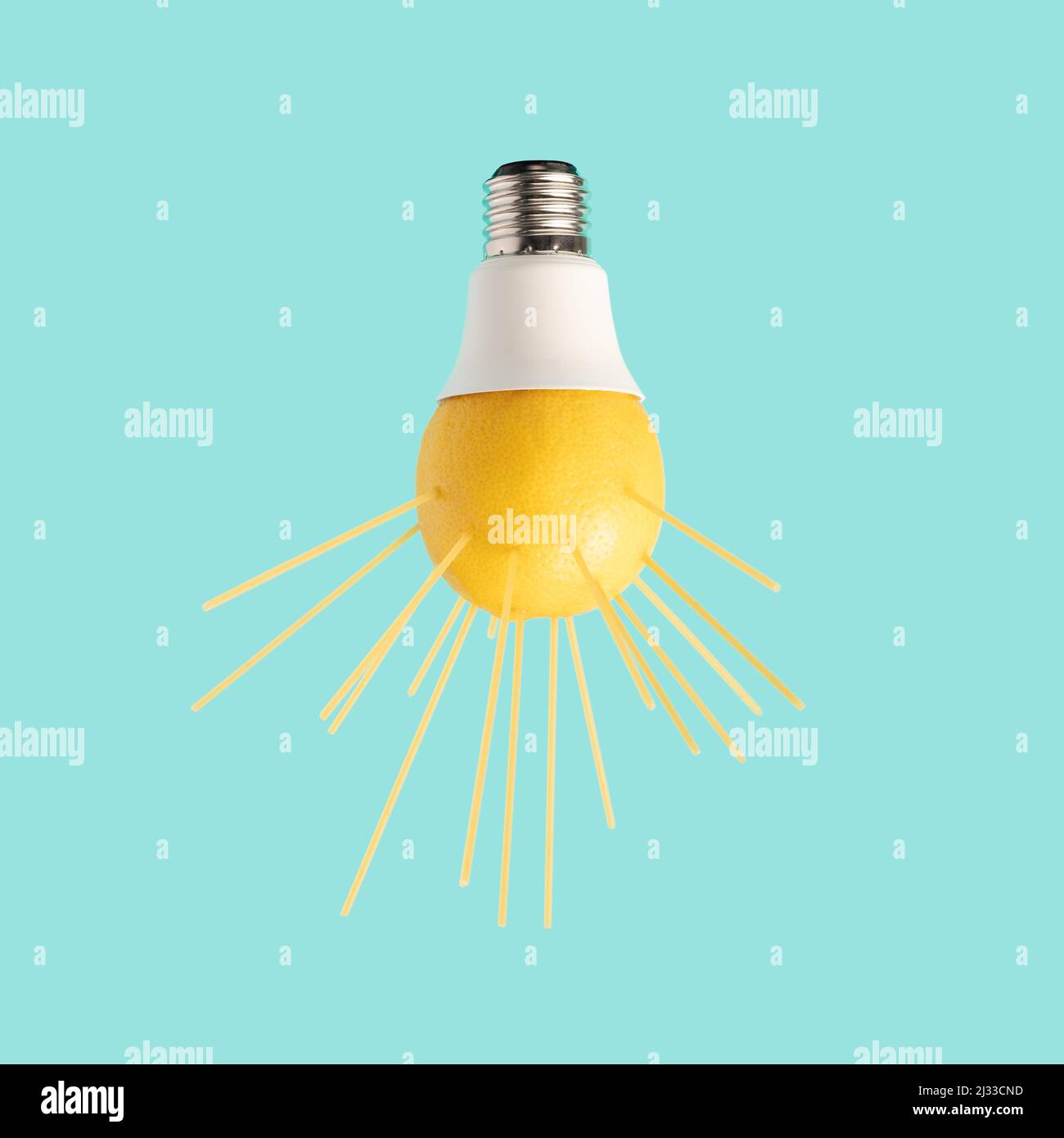 Ampoule avec des rayons de citron et de spaghetti sur fond bleu pastel. Pénurie d'électricité concept minimal. Banque D'Images