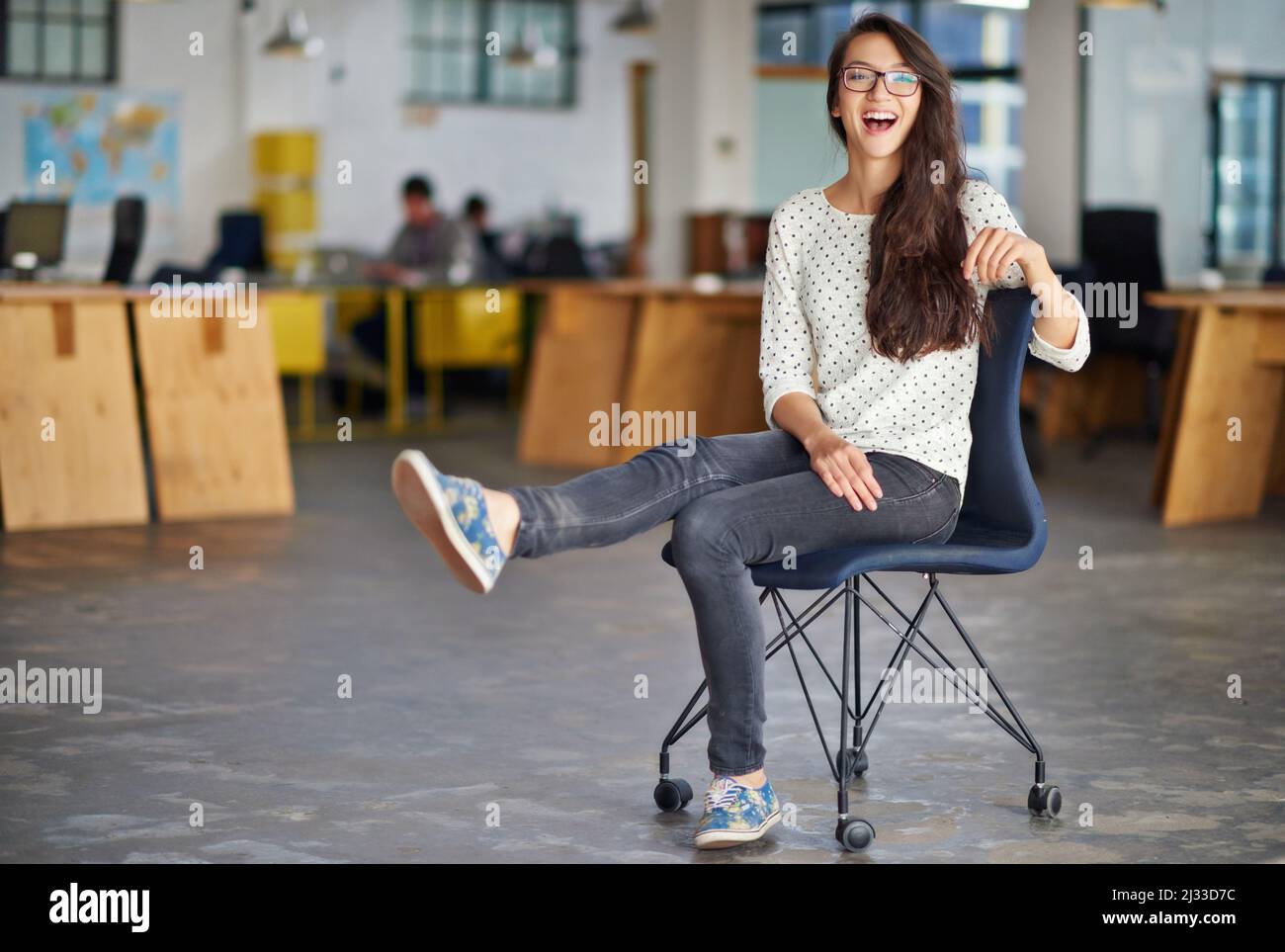 C'est un lieu de travail bien frais. Portrait d'une jeune femme attrayante assise dans un bureau. Banque D'Images