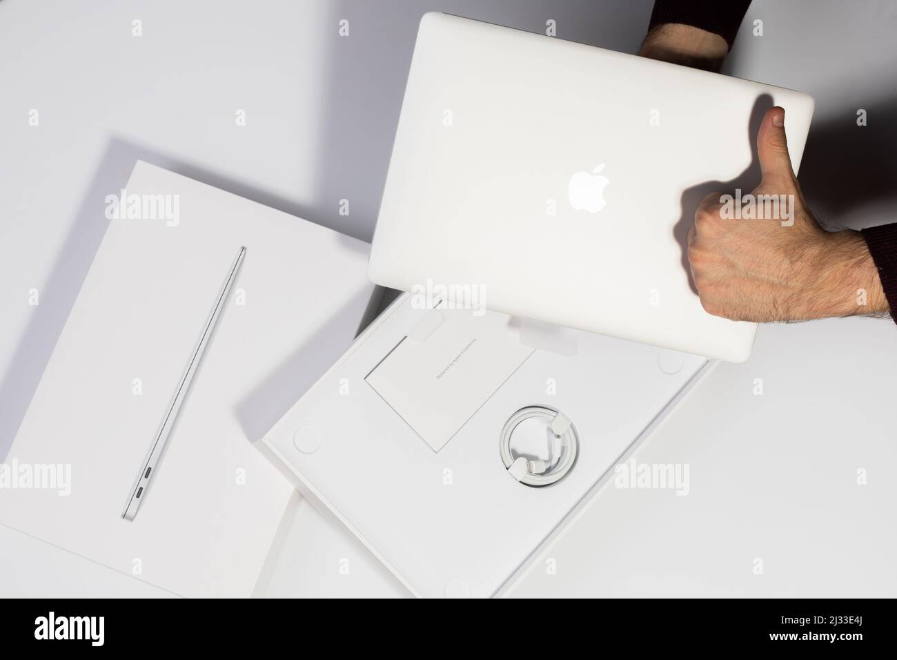 Saratov, Russie - 26 février 2022: Montrer l'excellente qualité de MacBook Air 13 pouces avec processeur M1, emballage avec charge, fond blanc Banque D'Images