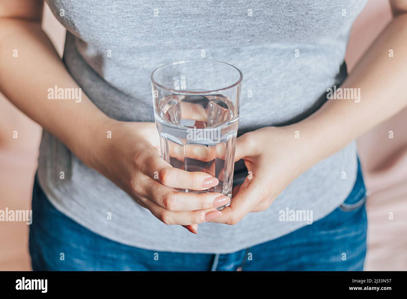 Journée mondiale de l'eau. Elle tient un verre d'eau propre dans ses mains. Concept de soins de santé. Boire de l'eau le matin pour stimuler le métabolisme. Banque D'Images