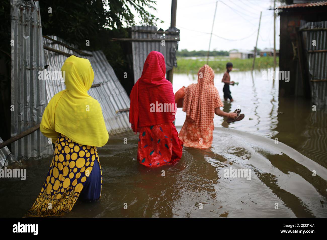 Le 15 juillet 2020, des femmes traversent les eaux inondées à Sunamganj, dans le nord-est du Bangladesh. Chaque année, des millions de personnes touchées par les inondations dues à de fortes pluies et à des cours d'eau débordant dans les parties nord-est et nord-ouest du Bangladesh. De nombreuses personnes sont mortes, déplacées, ont perdu leurs récoltes, leurs maisons, souffrent de nourriture et d'eau potable pure pendant l'inondation de la mousson. Banque D'Images