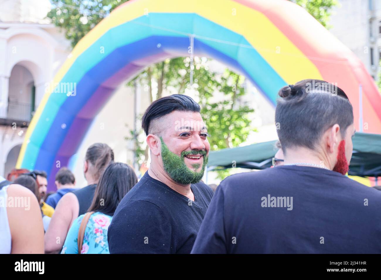 Buenos Aires, Argentine; 6 novembre 2021: LGBT Pride Parade. Homme avec des paillettes vertes dans sa barbe prenant part à la fête sous un arc-en-ciel. Banque D'Images