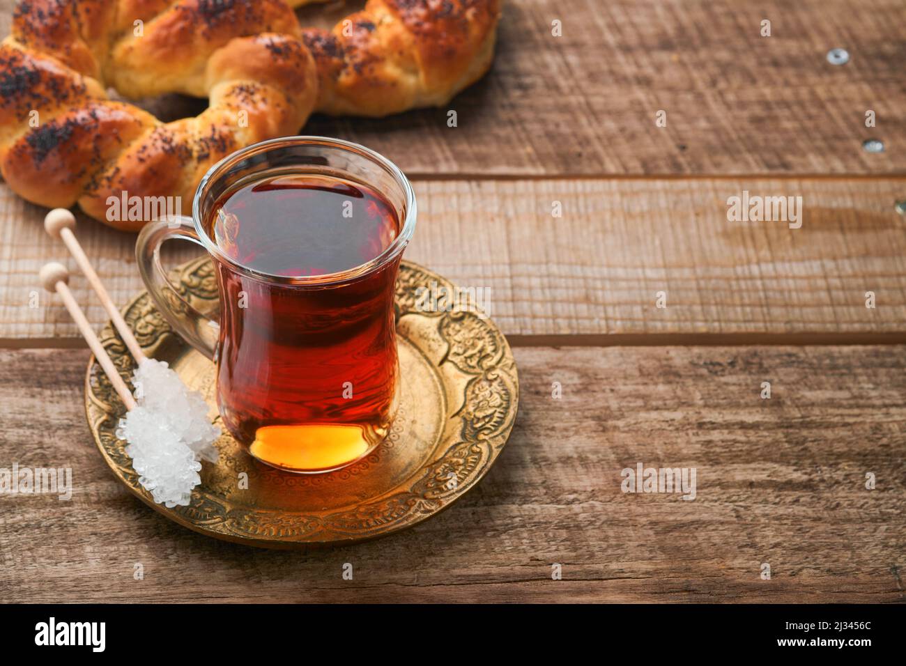 Thé noir turc. Tasse en verre de thé noir turc et bagel traditionnel turc croustillant sur fond de vieux rousstick. Concept de pâtisserie pour le petit déjeuner. Traditiona Banque D'Images