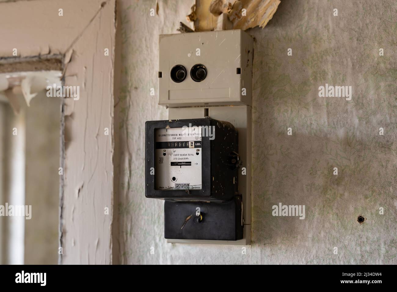 Ancien compteur électrique sur un mur dans un bâtiment abandonné. Equipement électrique pour