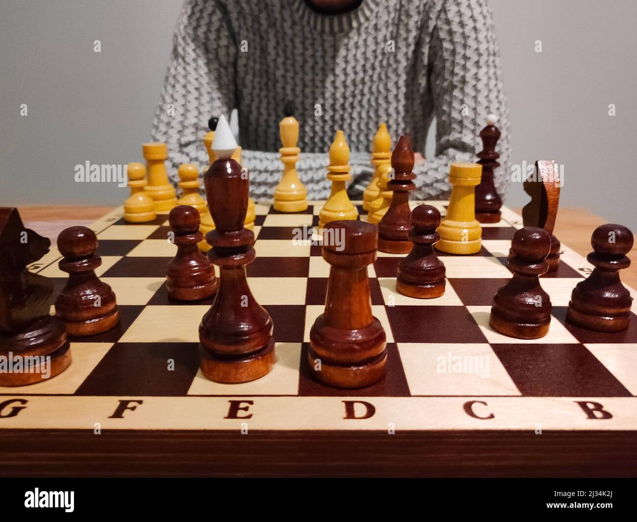 Homme pensant et analysant le jeu d'échecs sur le plateau d'échecs - concept stratégique. Banque D'Images