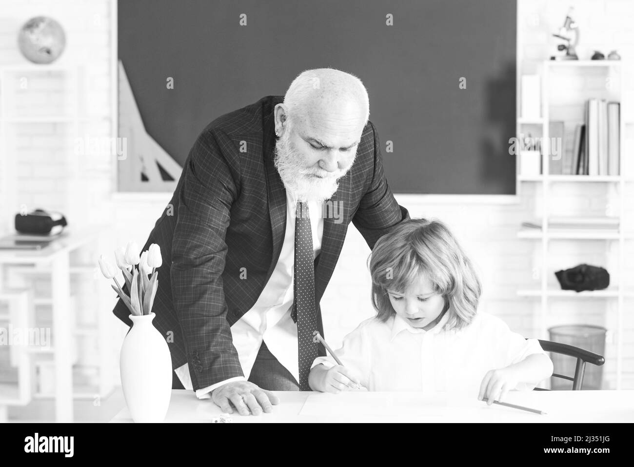 Un élève qui apprend en classe. L'enseignant de l'école aide à apprendre. Éducation, enseignement. Leçon enfant élève. Banque D'Images