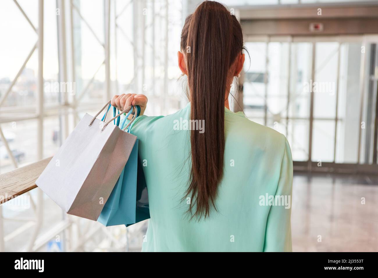 Jeune femme en tant que consommateur et consommateur avec beaucoup de sacs d'achats dans le centre commercial Banque D'Images