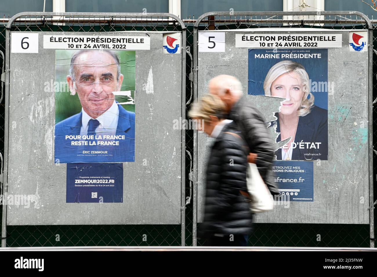 Paris, France, le 5 avril 2022, un vieux couple de piétons passe une affiche officielle de campagne du candidat d'extrême-droite Eric Zemmour (Reconquete), et celle de Marine le Pen (rassemblement National) sur un panneau d'affichage électoral (panneau). Affiches présidentielles sur leurs conseils électoraux. Illustration le 5 avril 2022 à Paris, France. Les électeurs français se dirigent vers les urnes pour voter le 10 avril 2022 pour le premier tour de l'élection présidentielle, pour élire leur nouveau président de la République. Photo de Victor Joly/ABACAPRESS.COM Banque D'Images