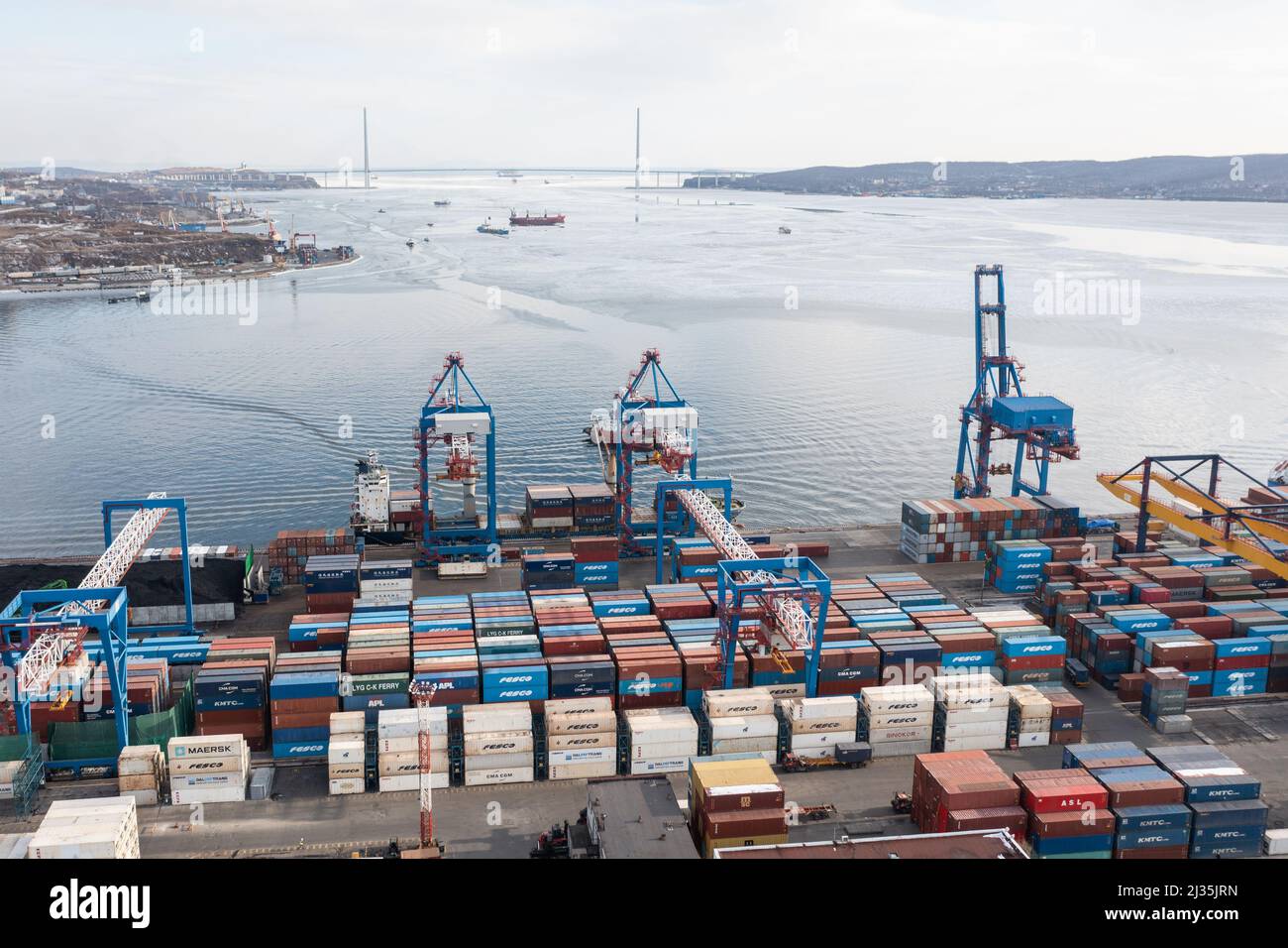 Vladivostok, Russie - 28 janvier 2022 : Vue de dessus du terminal des conteneurs du port maritime. En hiver, un bateau à conteneurs est en train de charger au quai. Banque D'Images